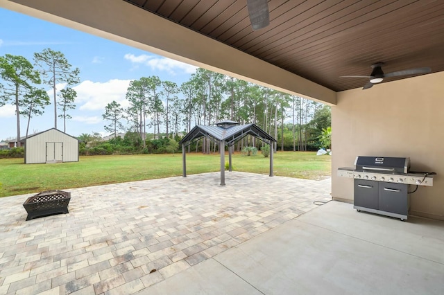 view of patio / terrace with ceiling fan, a storage unit, area for grilling, and an outdoor fire pit