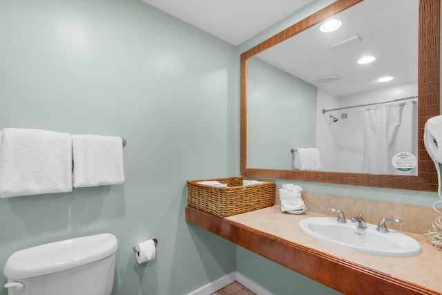 bathroom featuring sink, a shower with shower curtain, and toilet