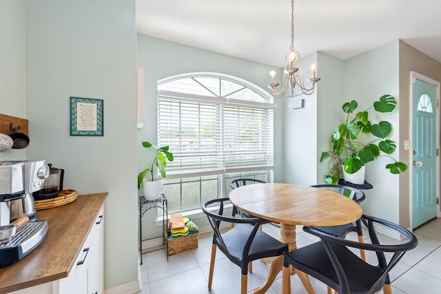 tiled dining area with an inviting chandelier and a textured ceiling