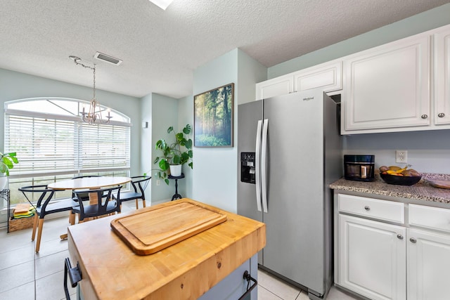 kitchen with white cabinets, hanging light fixtures, an inviting chandelier, and stainless steel refrigerator with ice dispenser