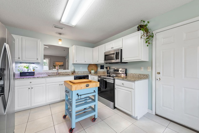 kitchen with sink, white cabinetry, a textured ceiling, and appliances with stainless steel finishes