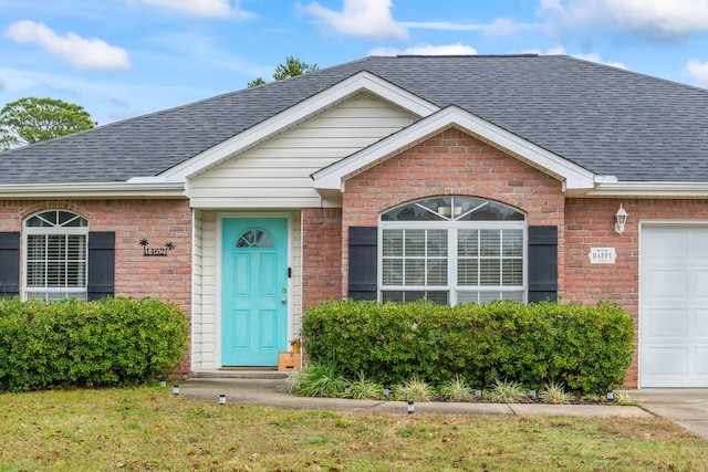 ranch-style house featuring a garage and a front lawn