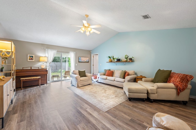 living room featuring ceiling fan, hardwood / wood-style floors, a textured ceiling, and vaulted ceiling