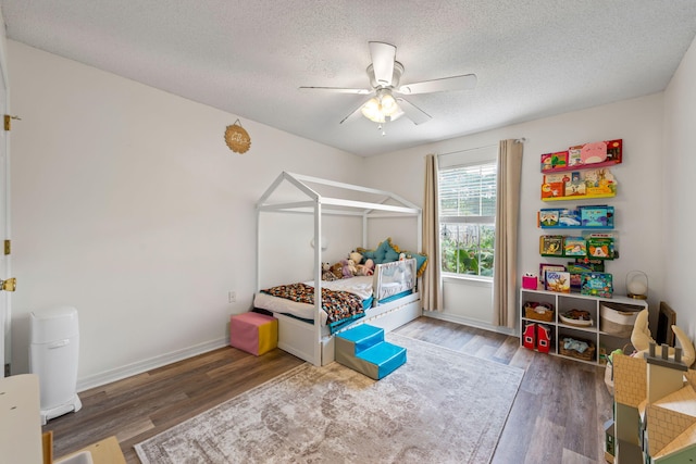 bedroom featuring ceiling fan, dark wood-type flooring, and a textured ceiling