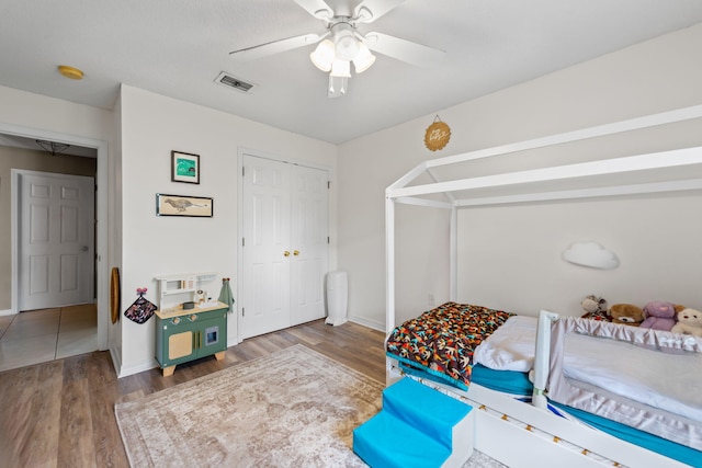 bedroom with ceiling fan, dark hardwood / wood-style floors, and a closet