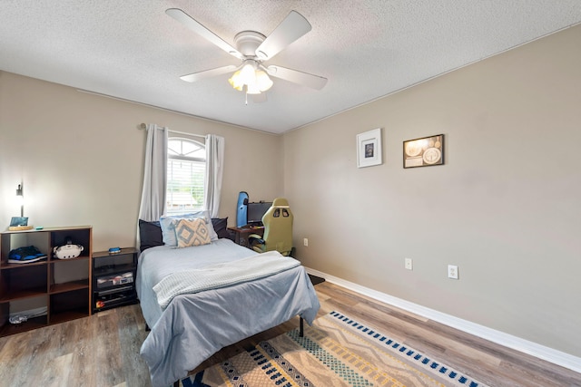 bedroom with wood-type flooring, a textured ceiling, and ceiling fan