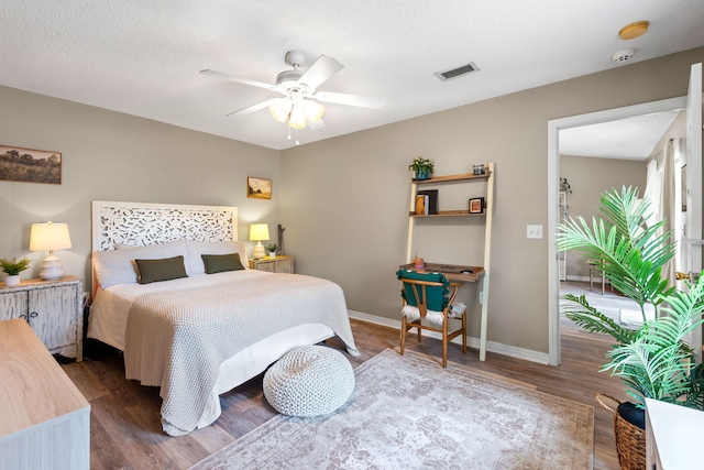 bedroom featuring ceiling fan, hardwood / wood-style floors, and a textured ceiling