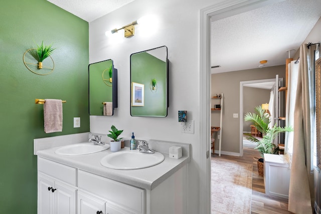 bathroom with vanity, hardwood / wood-style floors, and a textured ceiling