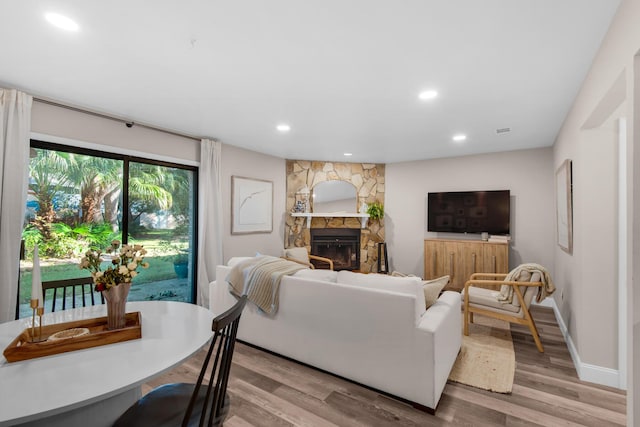 living room with a fireplace and light wood-type flooring