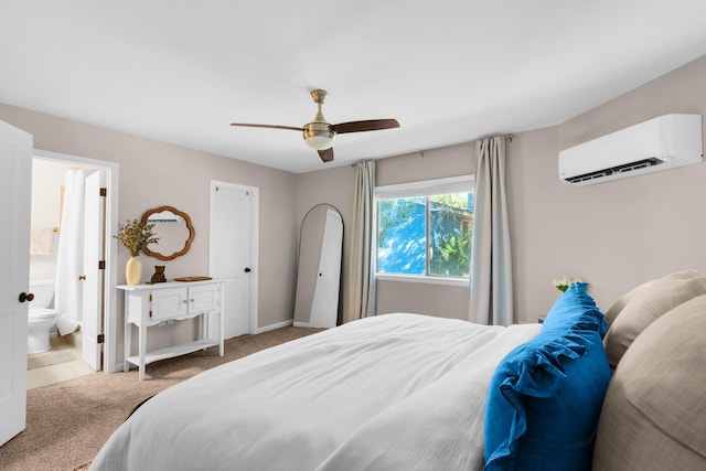 bedroom featuring ceiling fan, a wall mounted air conditioner, ensuite bathroom, and light colored carpet