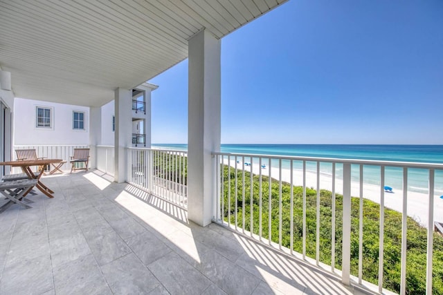 balcony featuring a view of the beach and a water view