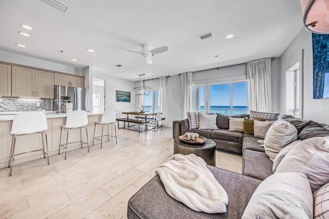 living room featuring a water view and ceiling fan