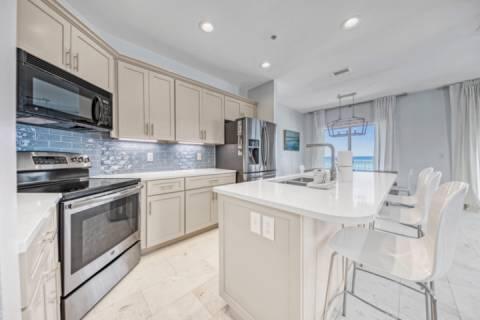 kitchen featuring appliances with stainless steel finishes, a kitchen island with sink, sink, hanging light fixtures, and a breakfast bar area