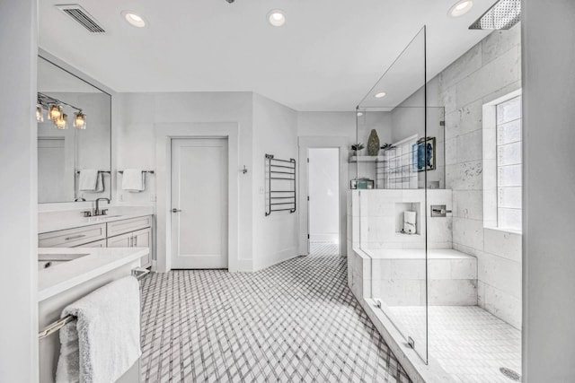 bathroom with vanity and a tile shower