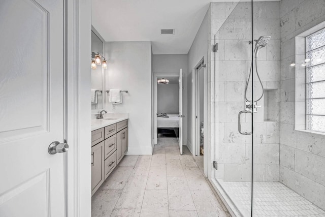 bathroom featuring a shower with door and vanity