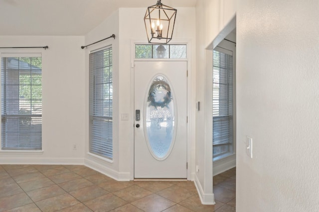 foyer entrance with an inviting chandelier and light tile patterned floors