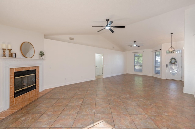 unfurnished living room with a tile fireplace, lofted ceiling, and ceiling fan