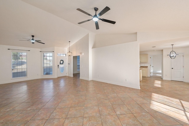 unfurnished living room with ceiling fan with notable chandelier, vaulted ceiling, and light tile patterned floors