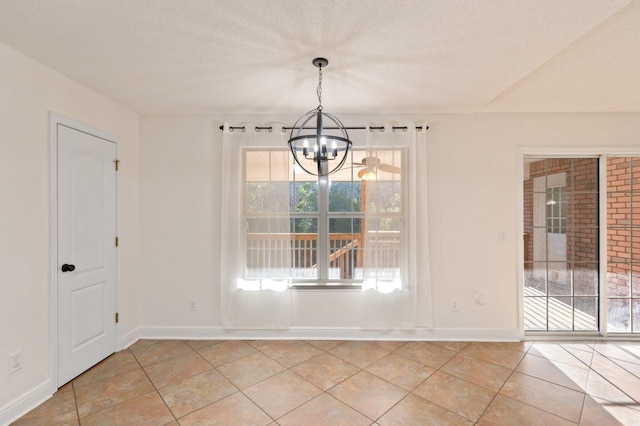 unfurnished dining area with light tile patterned floors, a textured ceiling, and a chandelier