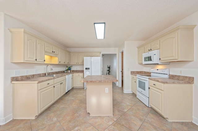 kitchen featuring white appliances, sink, cream cabinets, and a kitchen island