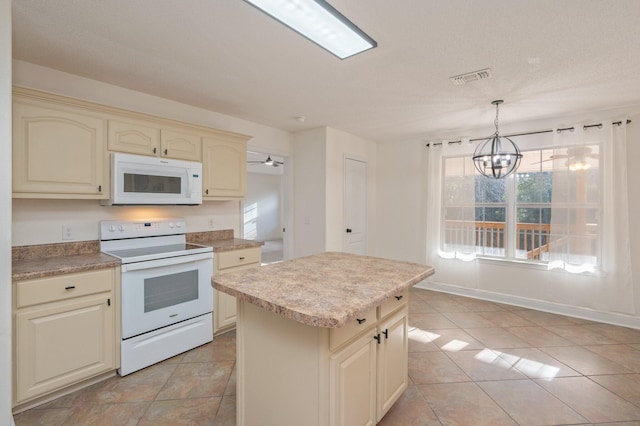 kitchen with white appliances, hanging light fixtures, cream cabinets, a kitchen island, and a chandelier