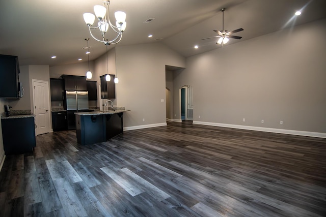 kitchen with light stone counters, sink, stainless steel appliances, and hanging light fixtures