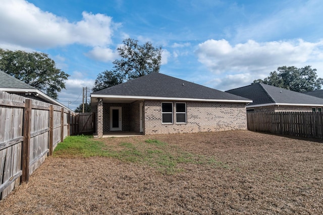 rear view of house with a yard and a patio area