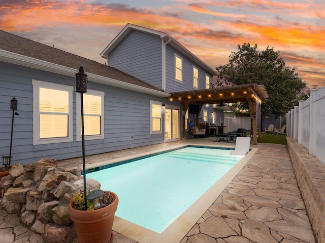 pool at dusk featuring a patio area