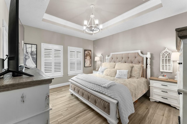 bedroom featuring a raised ceiling and a chandelier