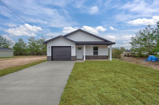 view of front of home featuring covered porch, a garage, and a front yard