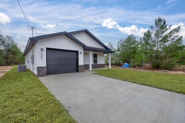 view of front facade with a front lawn, central AC unit, and a garage