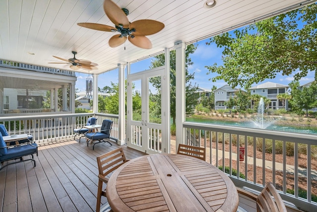 sunroom with ceiling fan, a water view, and wood ceiling