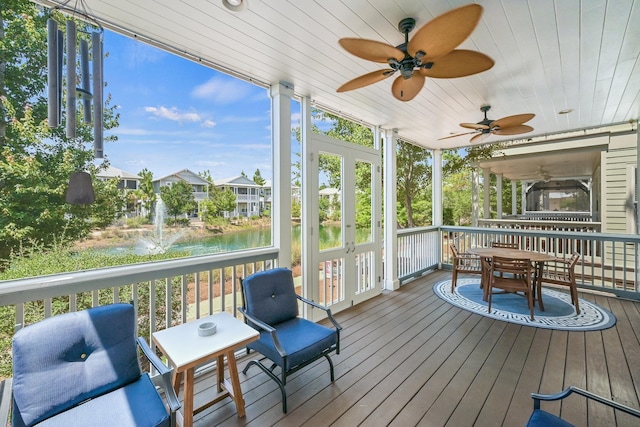 sunroom / solarium featuring a water view, ceiling fan, and wooden ceiling