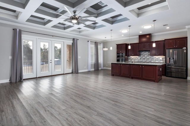 kitchen featuring an island with sink, appliances with stainless steel finishes, crown molding, and hanging light fixtures