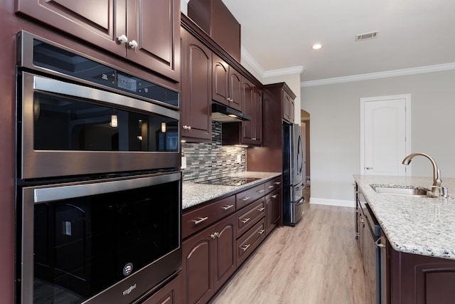 kitchen with appliances with stainless steel finishes, crown molding, light stone counters, sink, and backsplash