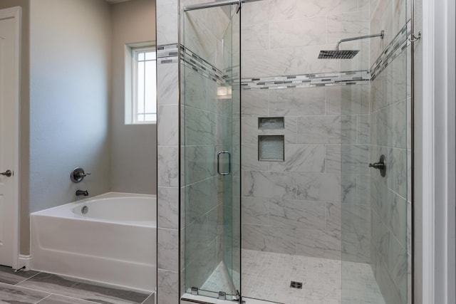 bathroom featuring shower with separate bathtub