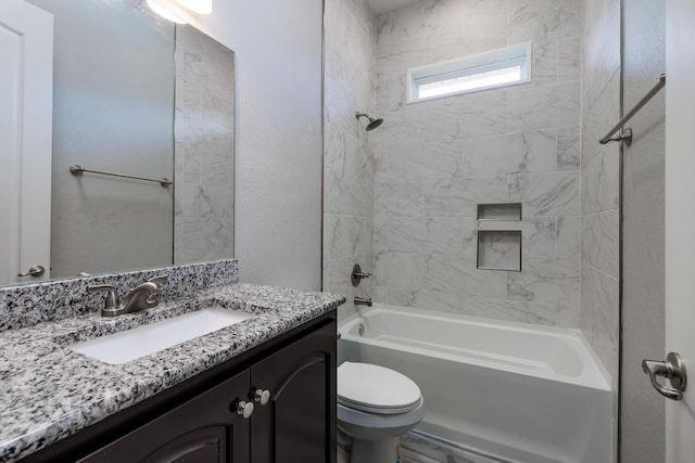 full bathroom with toilet, vanity, and tiled shower / bath