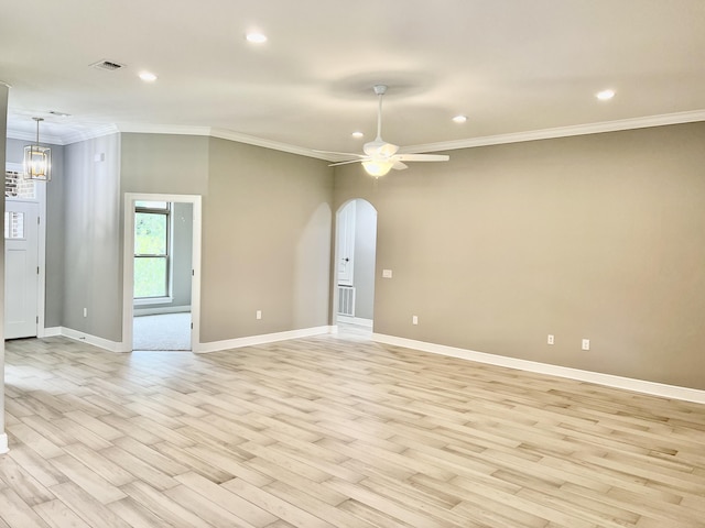 empty room with ceiling fan with notable chandelier, light wood-type flooring, and crown molding