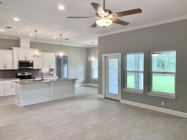 kitchen featuring stainless steel appliances, stone countertops, an island with sink, and white cabinetry