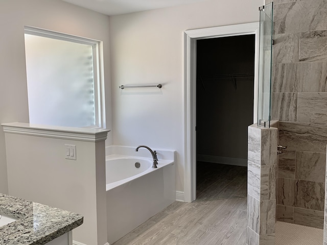 bathroom featuring shower with separate bathtub, vanity, and hardwood / wood-style flooring