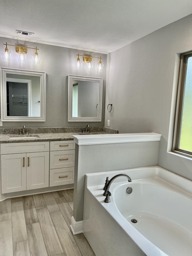 bathroom with vanity, hardwood / wood-style flooring, and a bathing tub