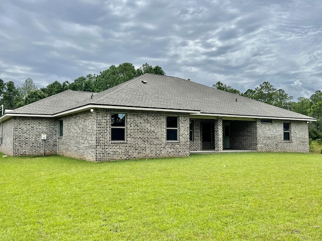 rear view of house featuring a yard