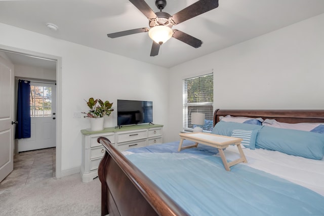 bedroom with light colored carpet, baseboards, and ceiling fan