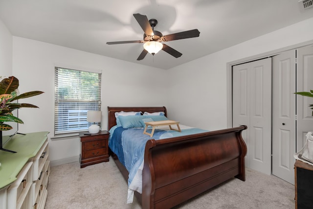 bedroom featuring visible vents, light carpet, a closet, and a ceiling fan