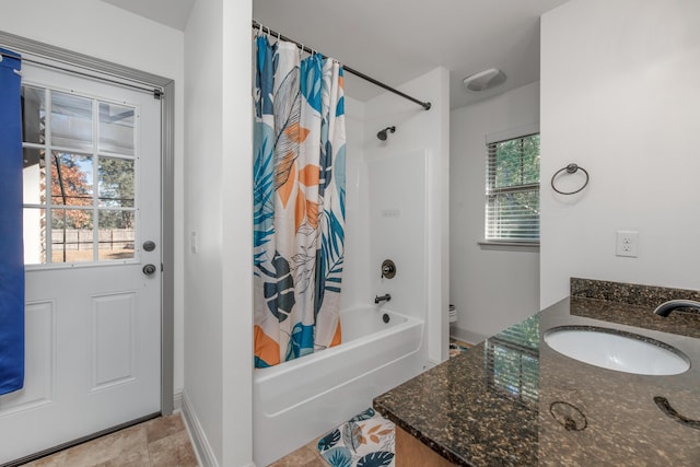 bathroom with vanity, toilet, shower / tub combo with curtain, and baseboards