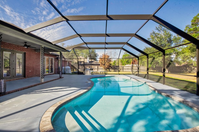 outdoor pool with french doors, fence, a lanai, and a patio area