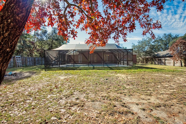 view of yard with glass enclosure and a fenced backyard