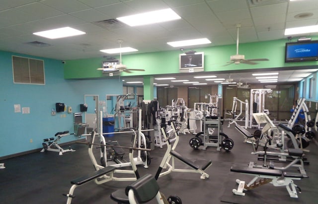 workout area featuring baseboards, a paneled ceiling, visible vents, and ceiling fan