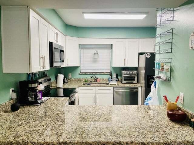 kitchen featuring light stone countertops, white cabinets, appliances with stainless steel finishes, and sink