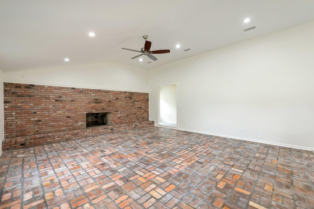 unfurnished living room with ceiling fan, a brick fireplace, and vaulted ceiling